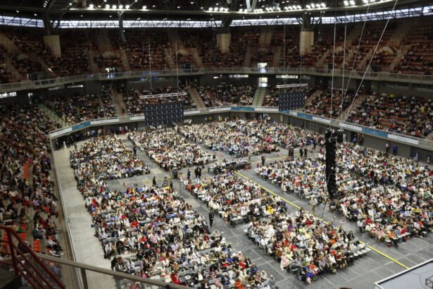Miles de personas en un estadio techado durante una convención de los testigos de Jehová.